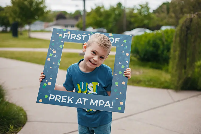 Prospective pre-K student holding an MPA welcome frame