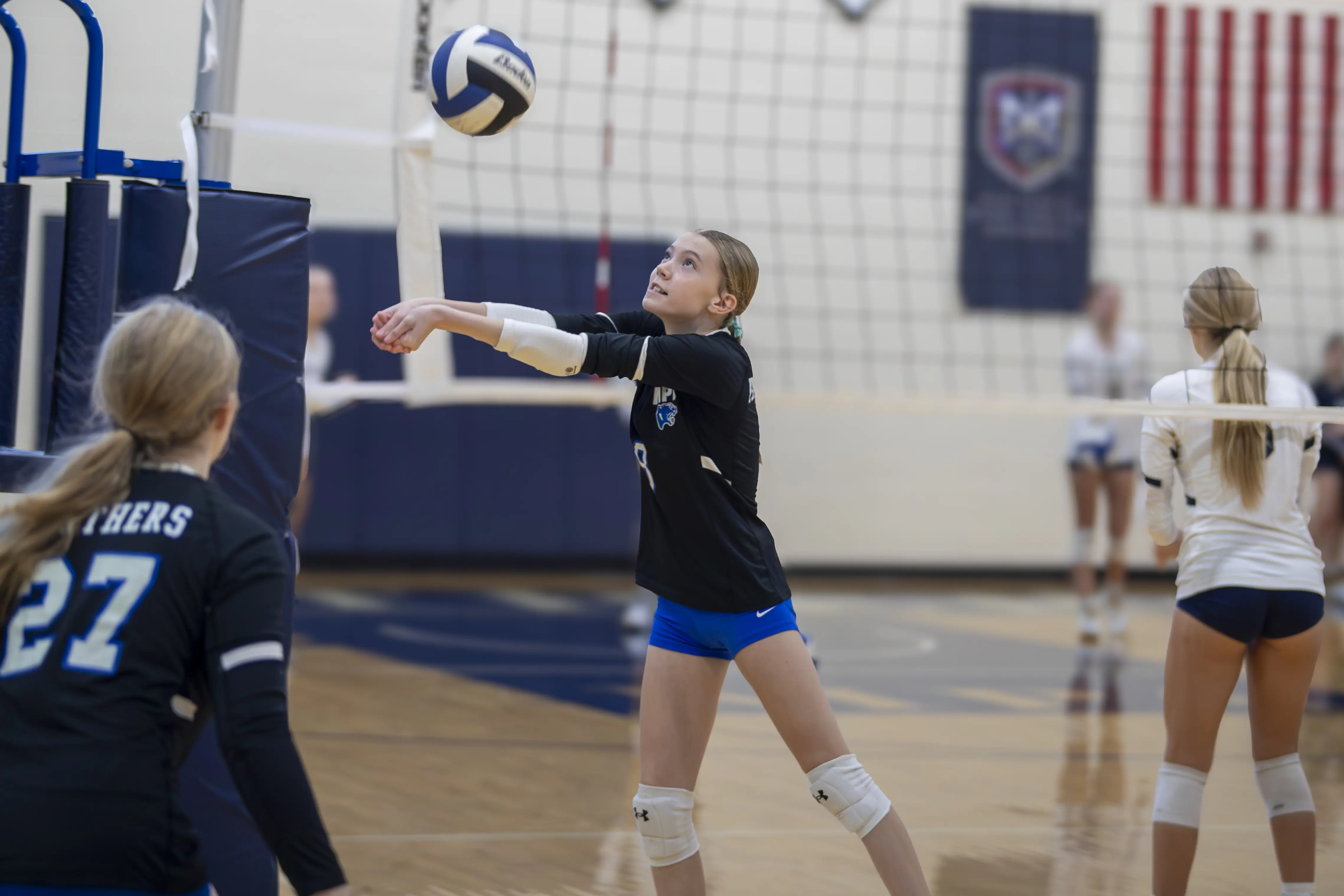 Student serving the ball during a volleyball match