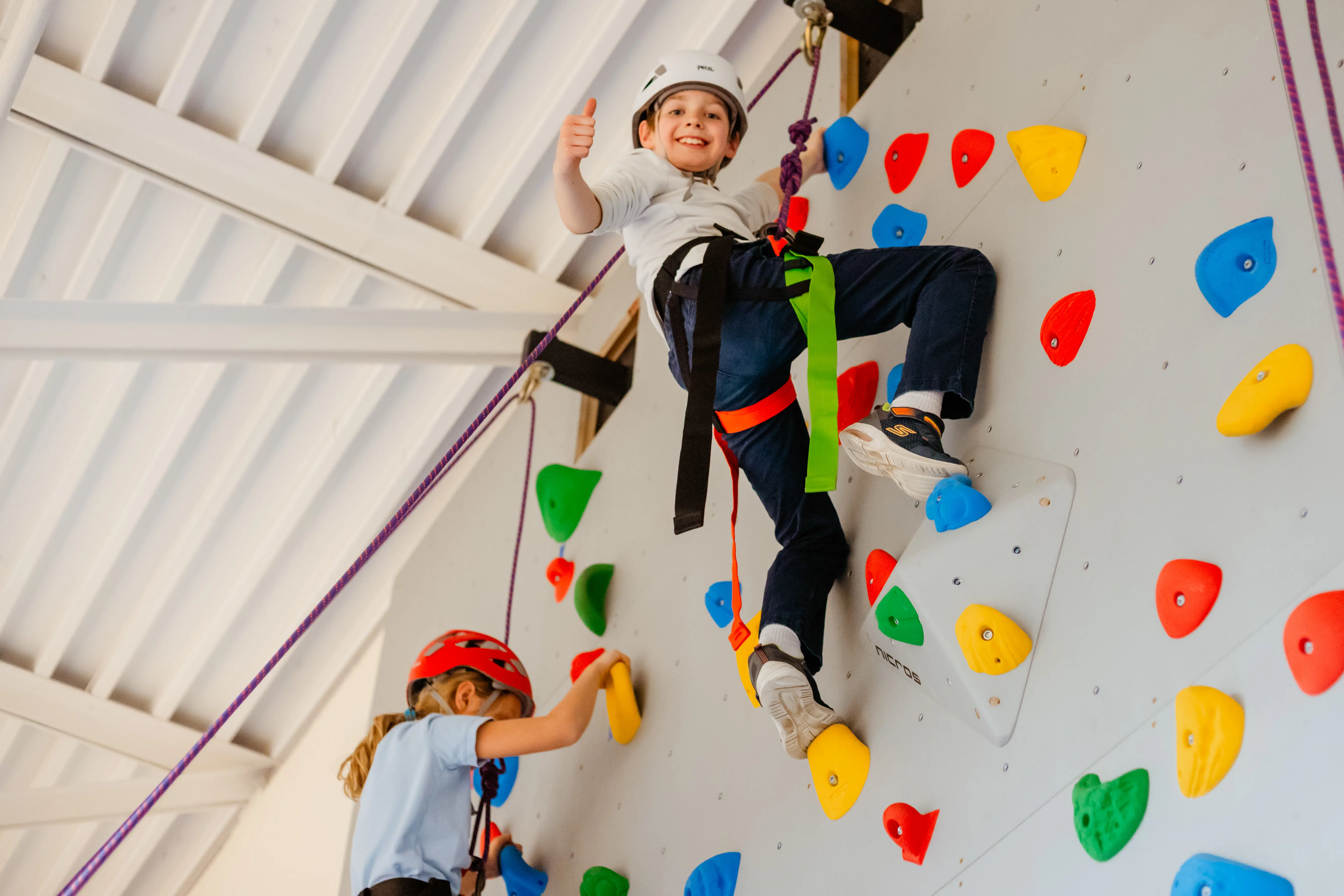 Students climbing the indoor rock wall