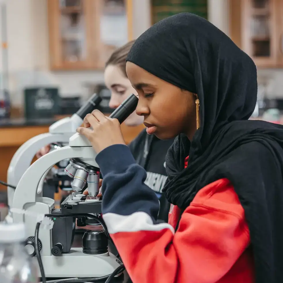 student looking through a microscope