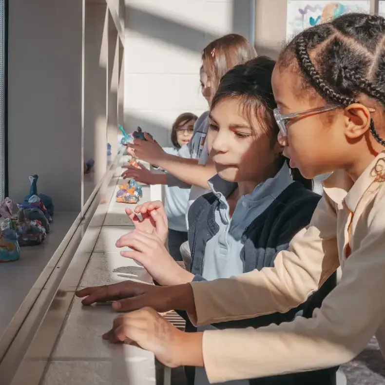 lower school students looking at their art sculpures