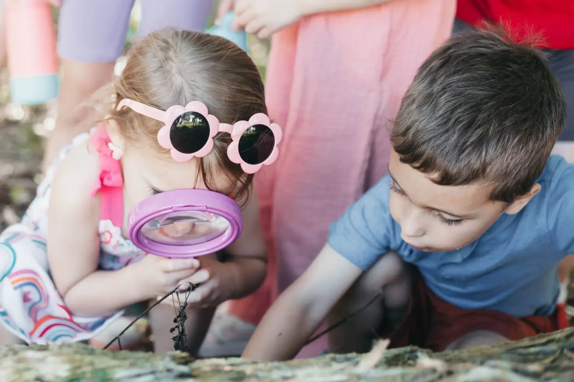 Students exploring nature with magnifying glasses