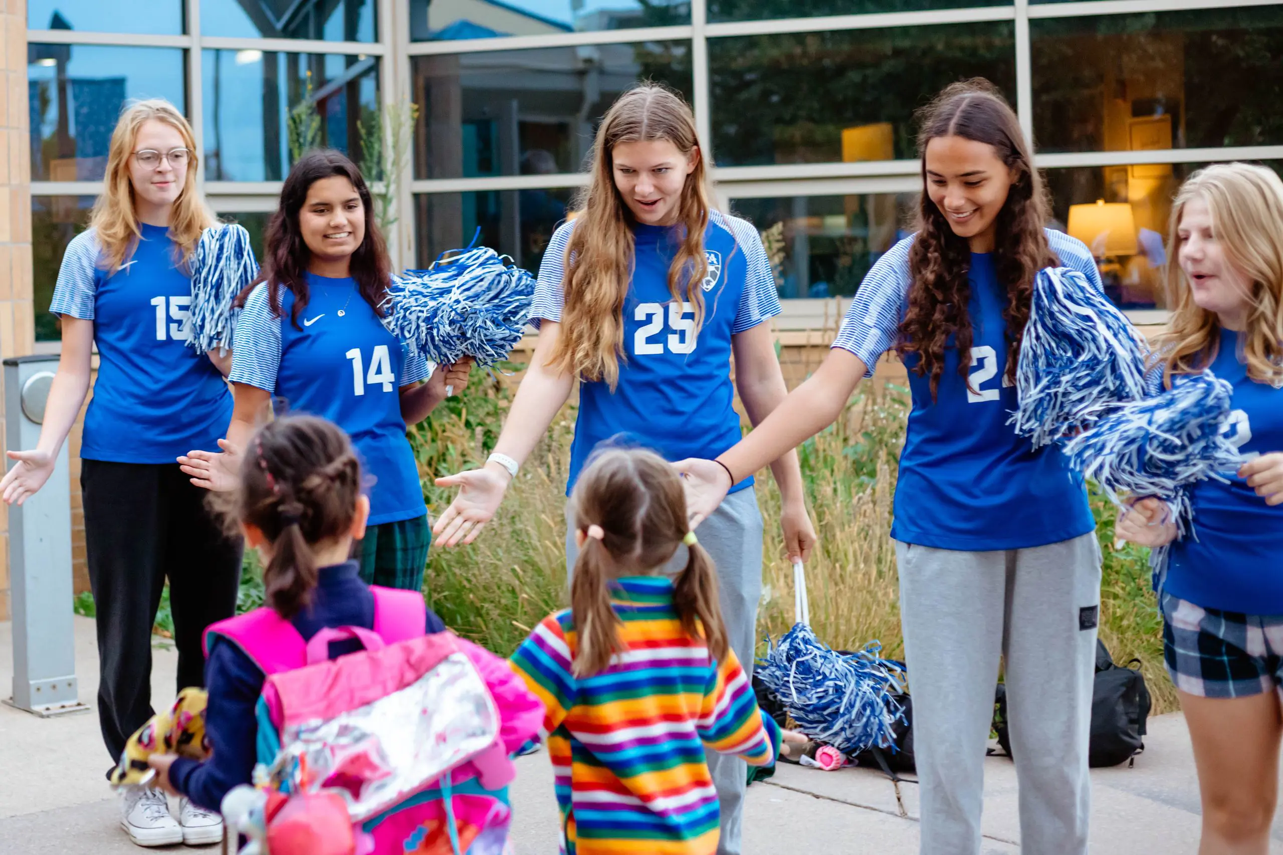 Cheer team waving to lower school students