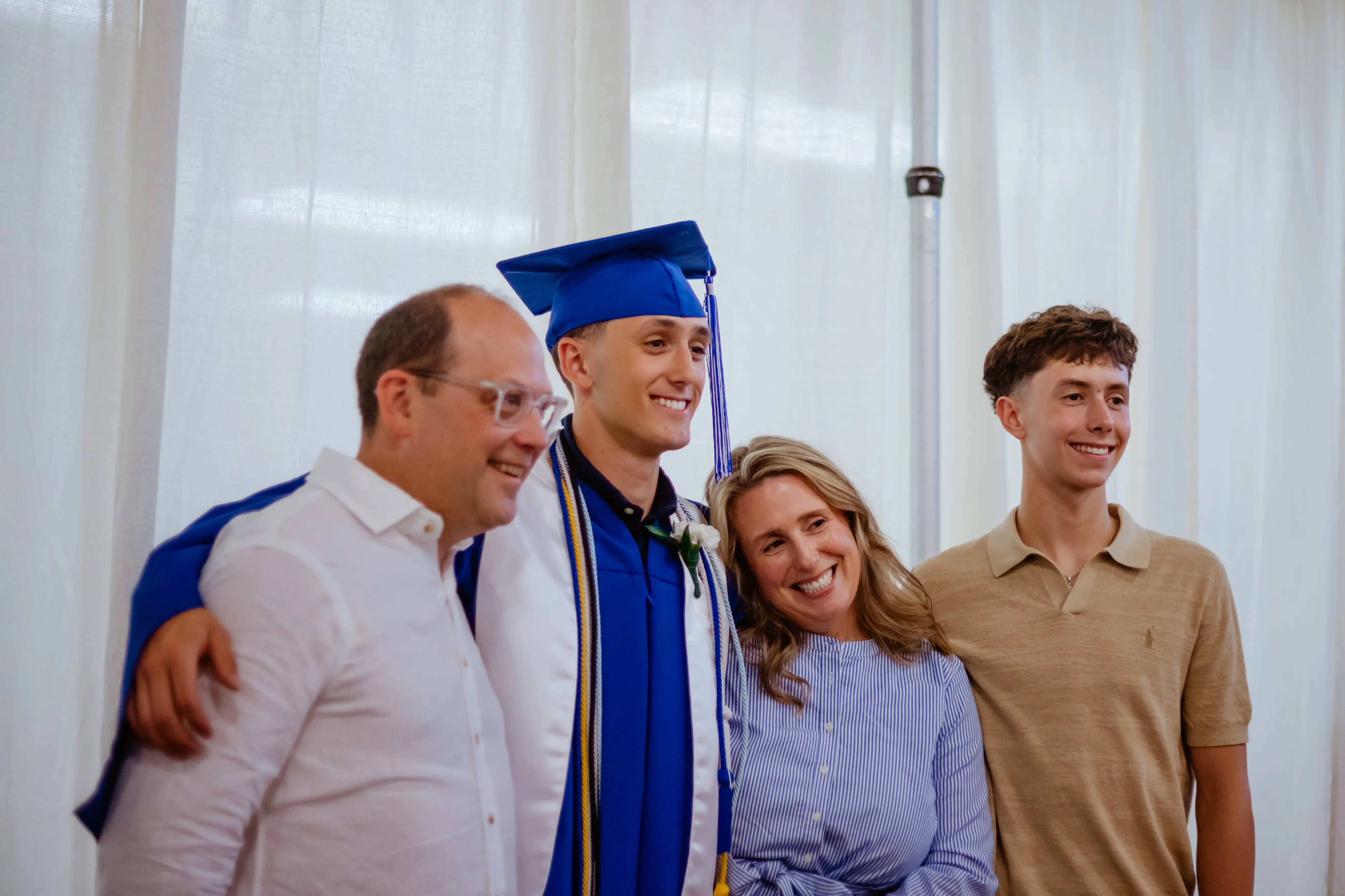 Graduate posing with family after commencement.