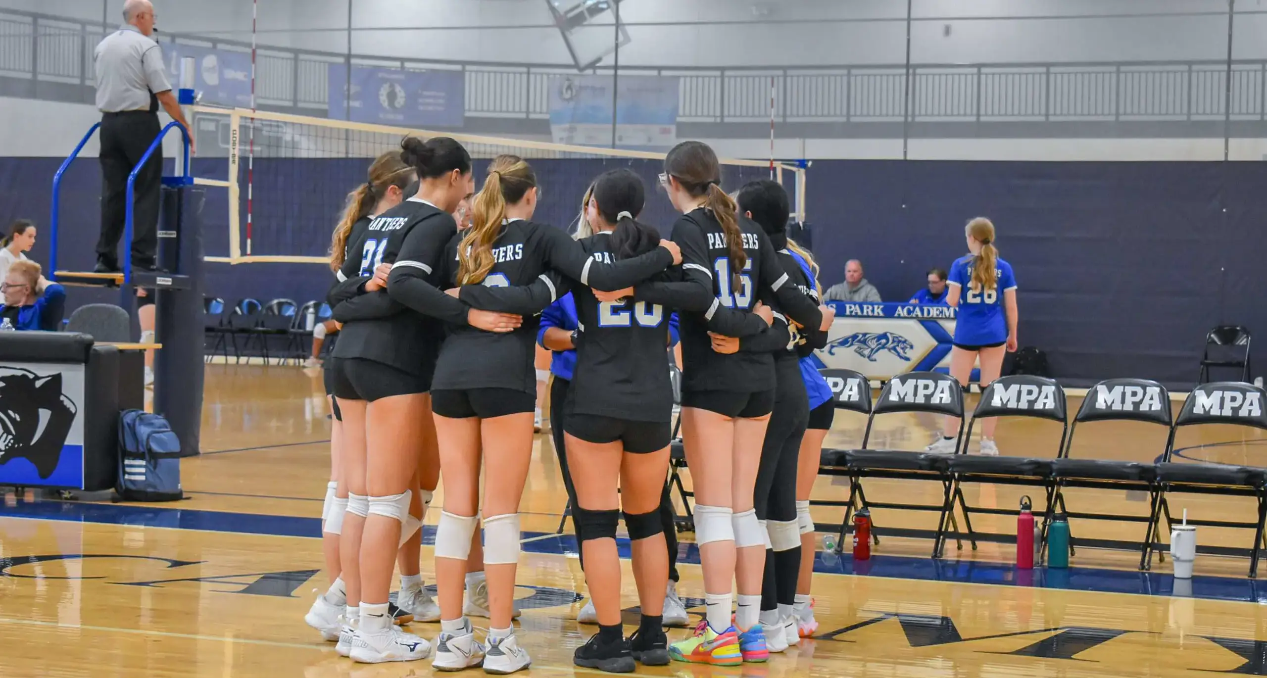 Volleyball team huddling before a match