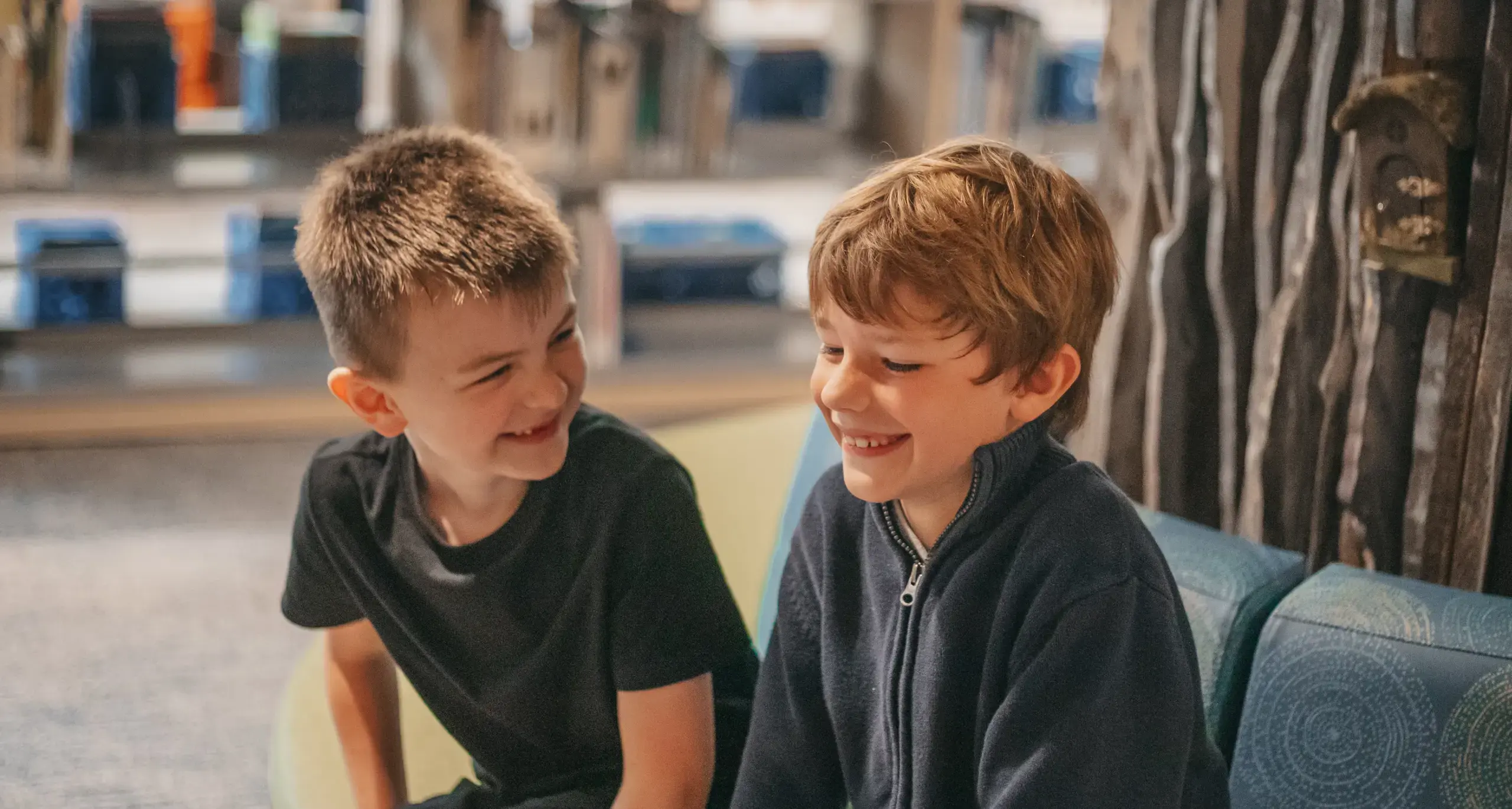 Two students smiling together in the school library.