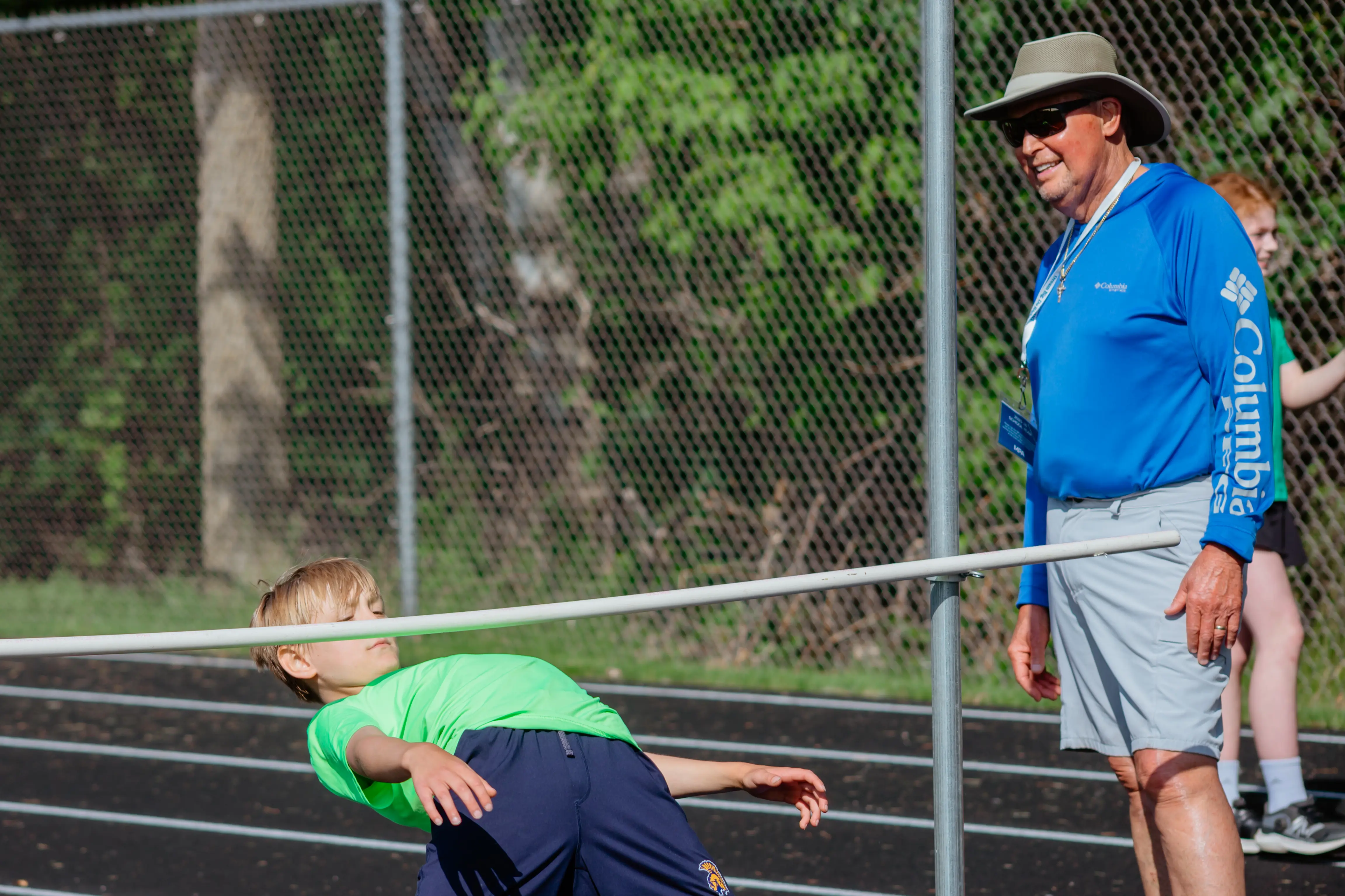 Student participating in the high jump at field day.