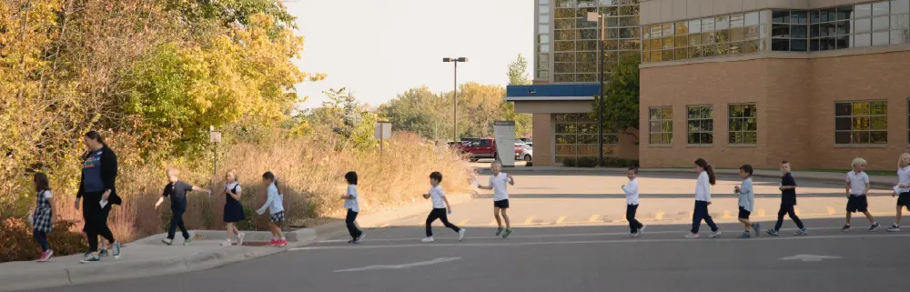 Lower school students crossing the road with teacher guidance
