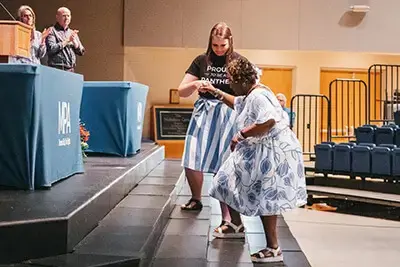 Photo of Jaye walking up the stairs to receive an award