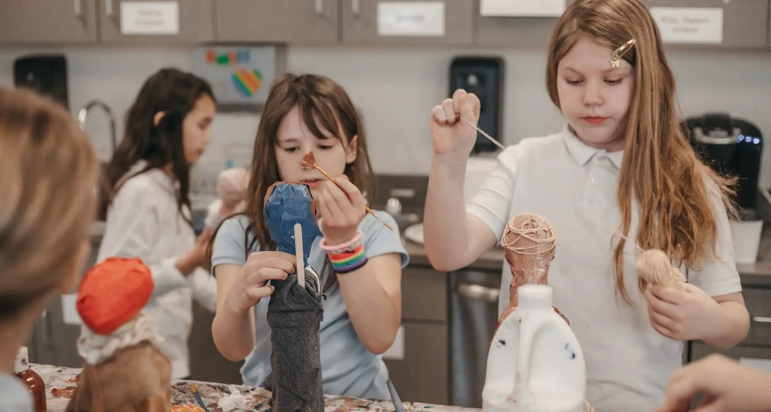 Lower school students creating papier-mâché projects.