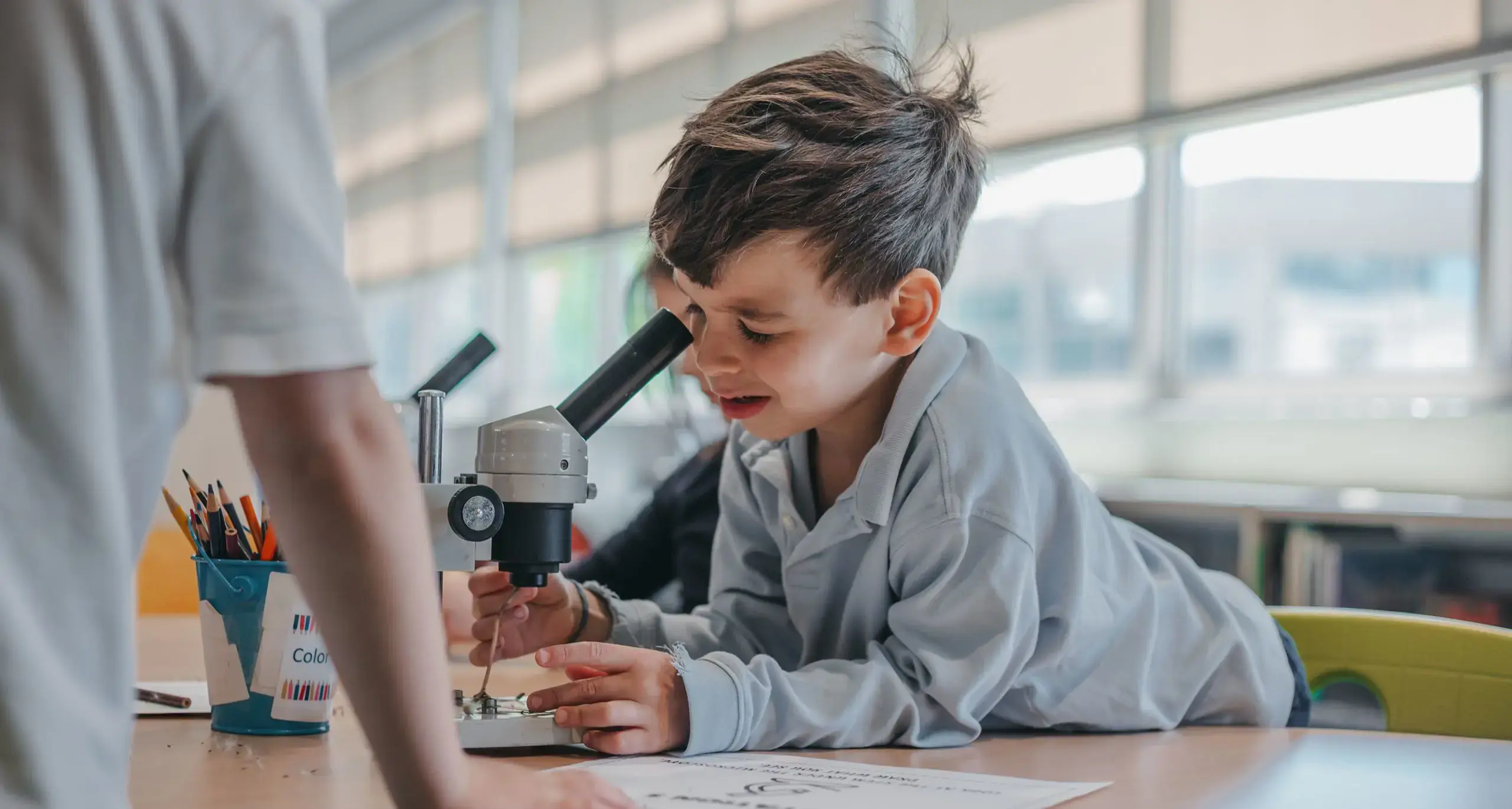 Lower school student looking through a microscope