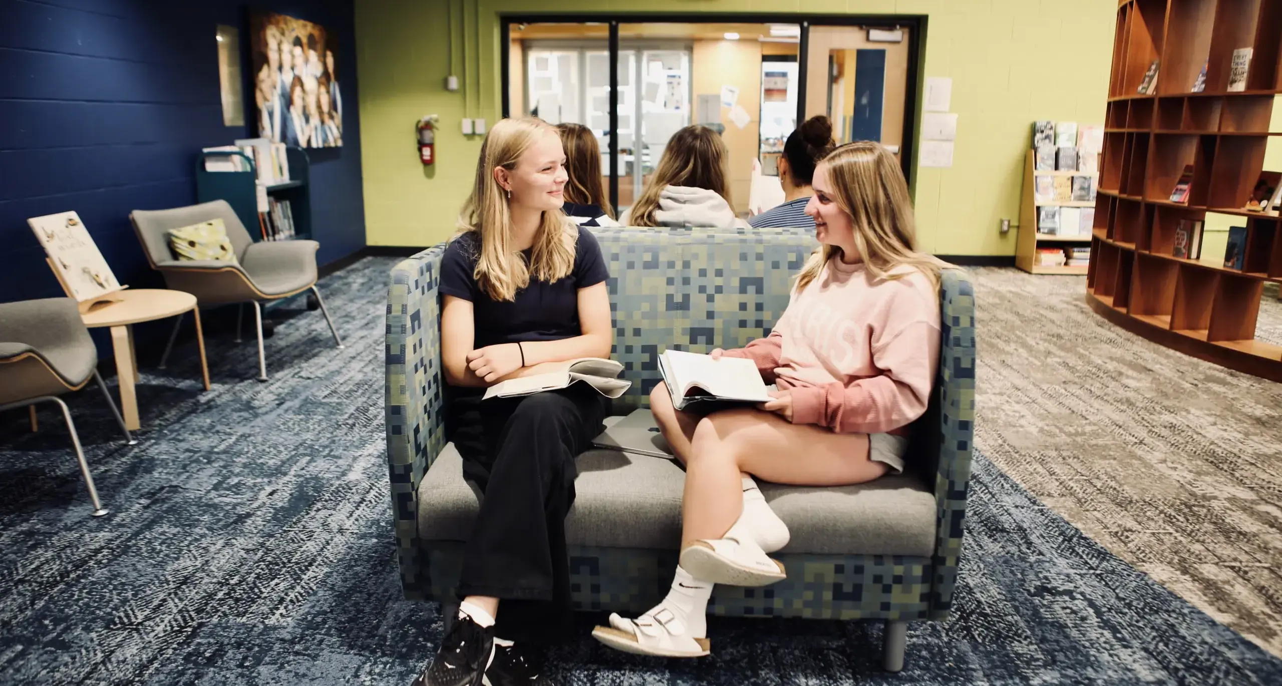 Two high school students studying together in the library.