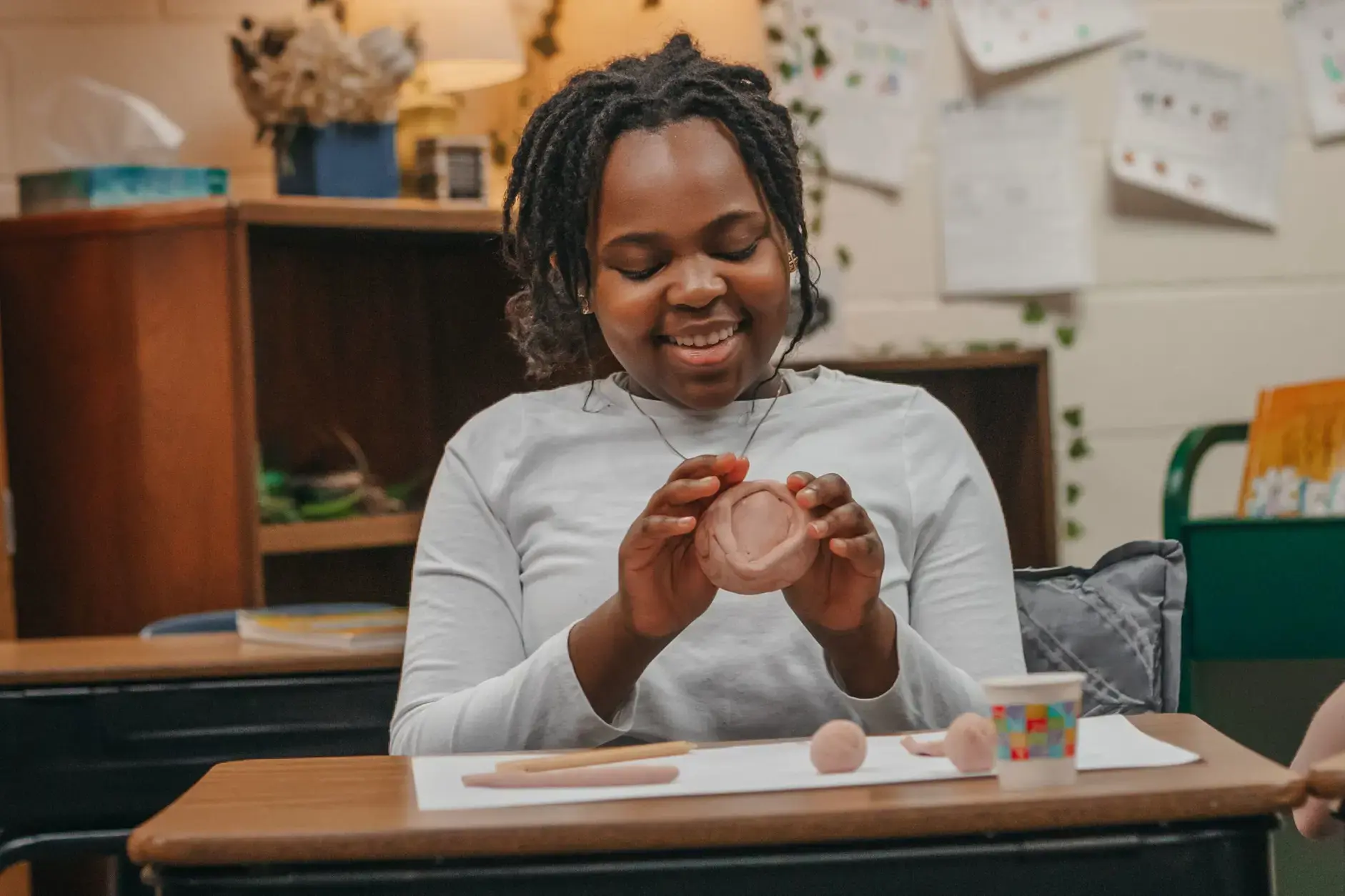 Student creating clay artwork in pottery class