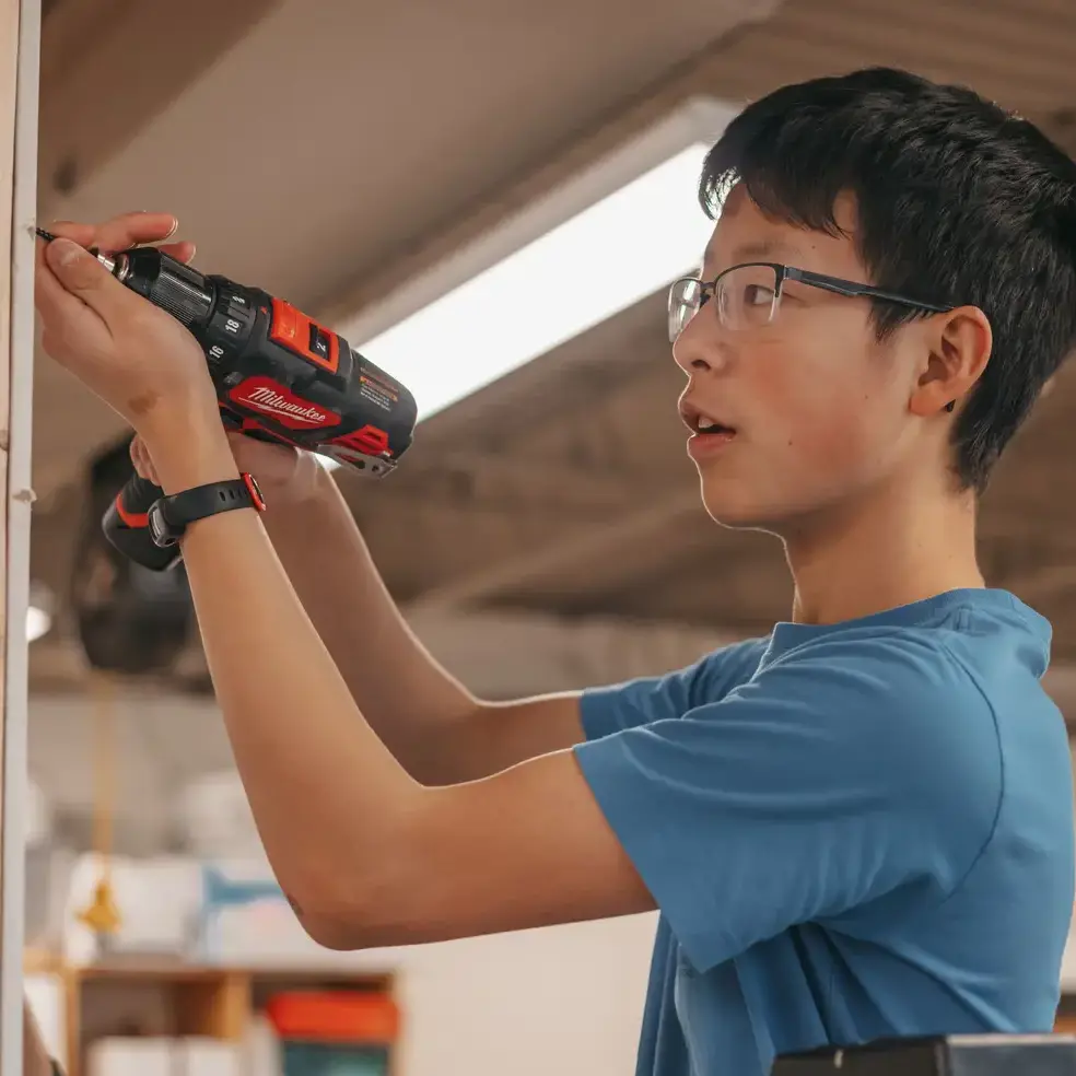 middle school student using a drill