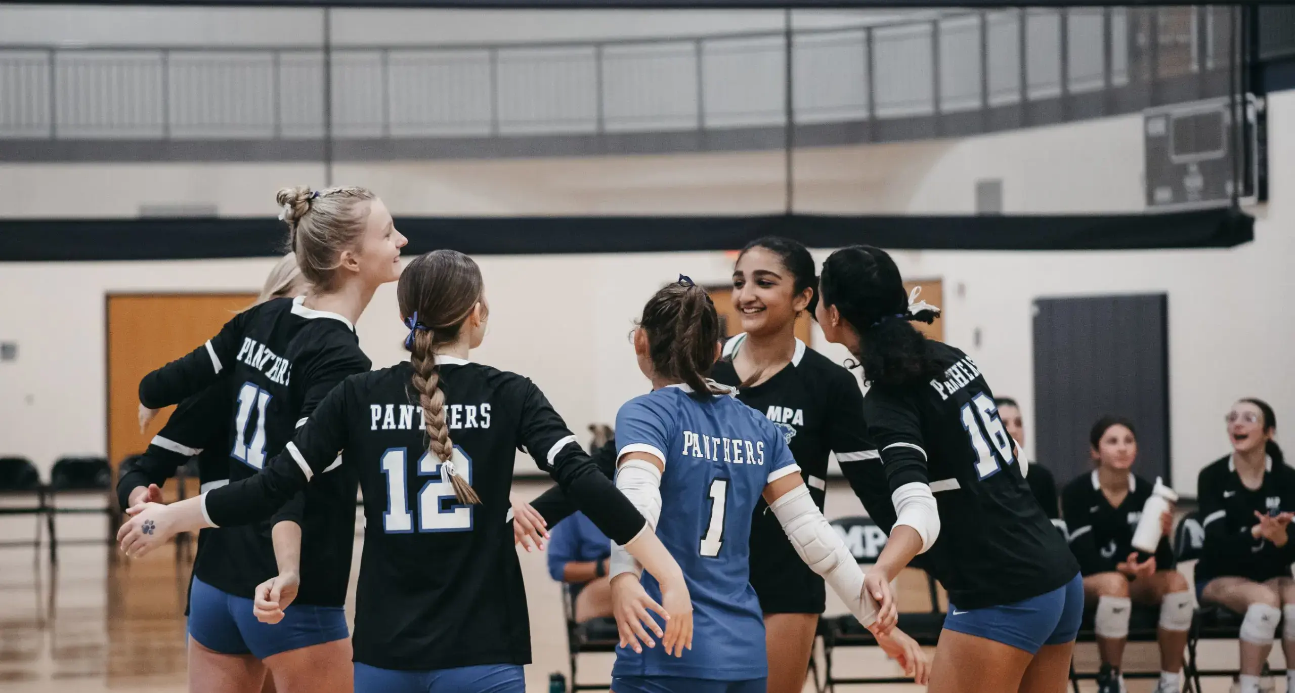 Students celebrating during a volleyball game.