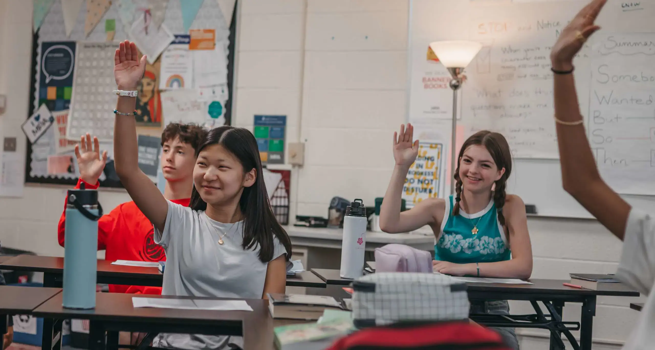 Students raising their hands in class