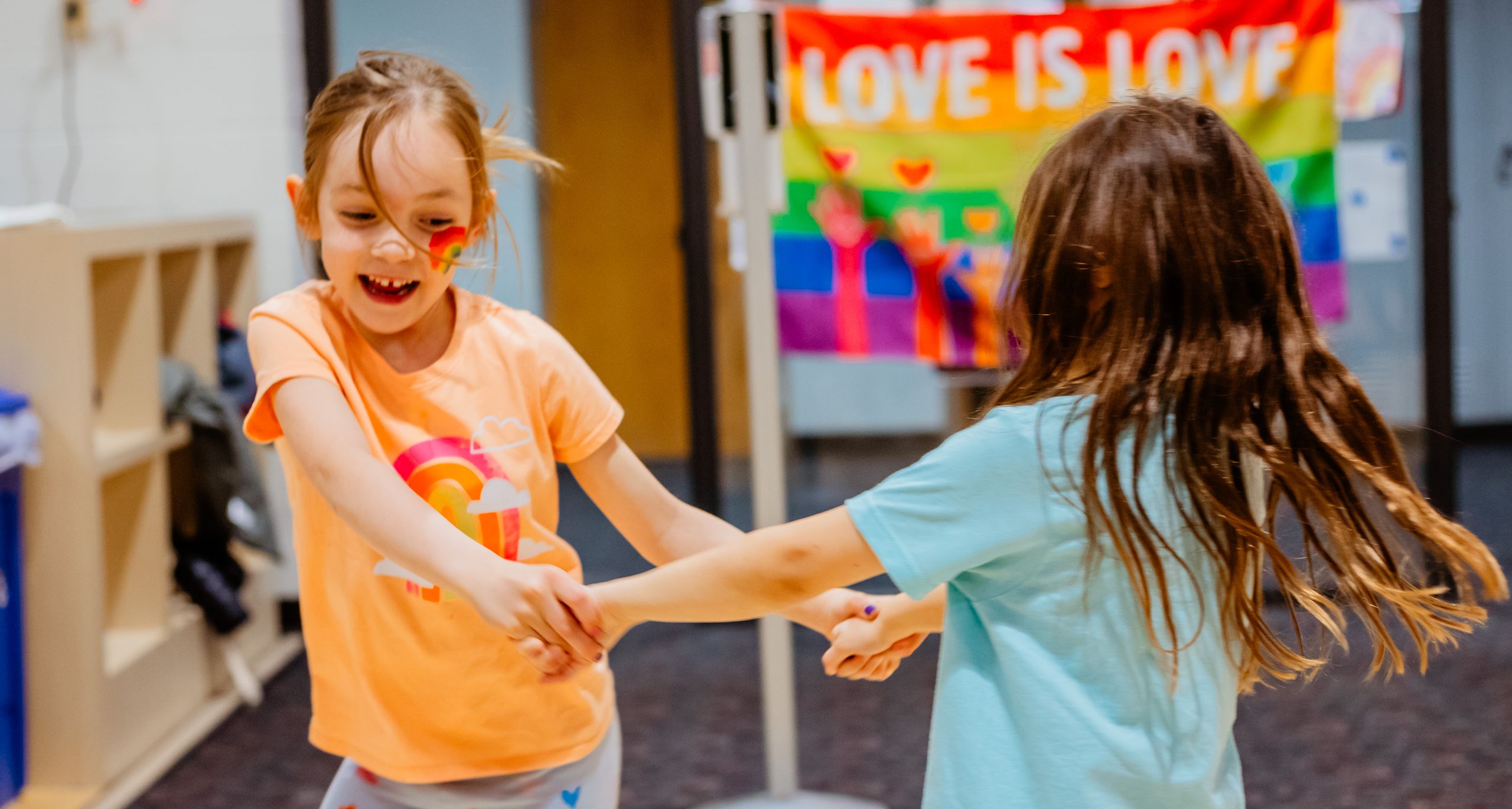 Two young students holding hands and dancing together
