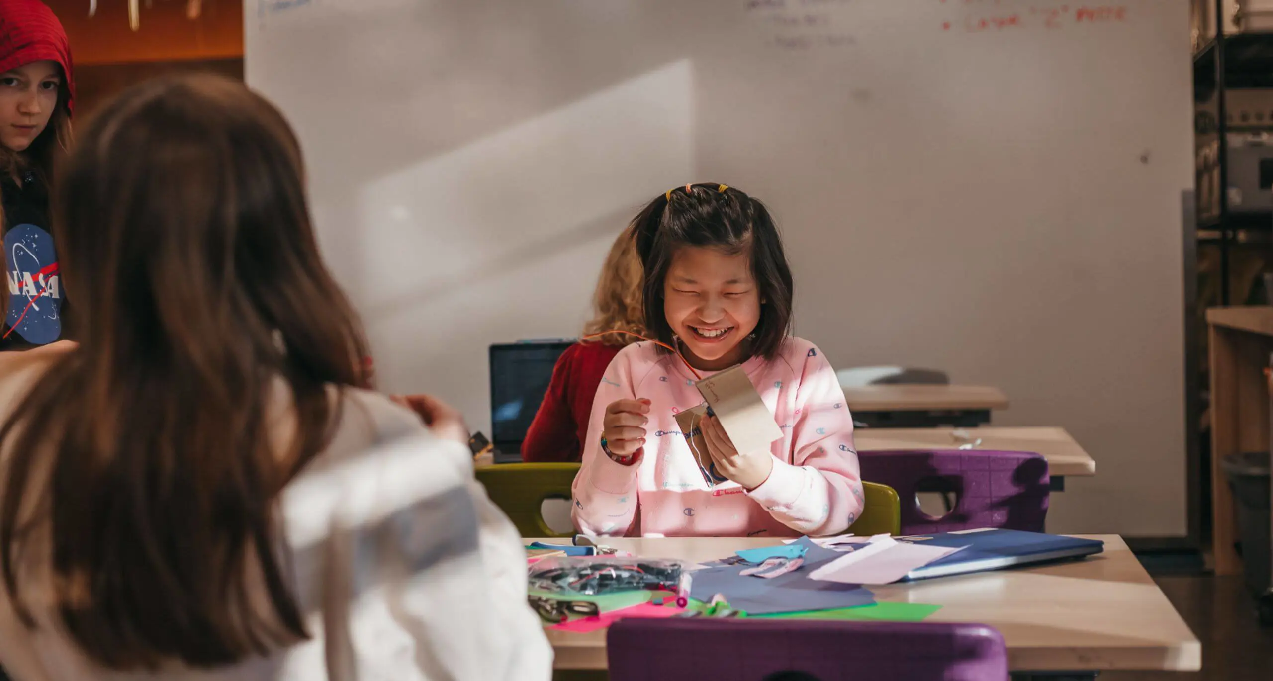 Student smiling while creating a classroom craft project.
