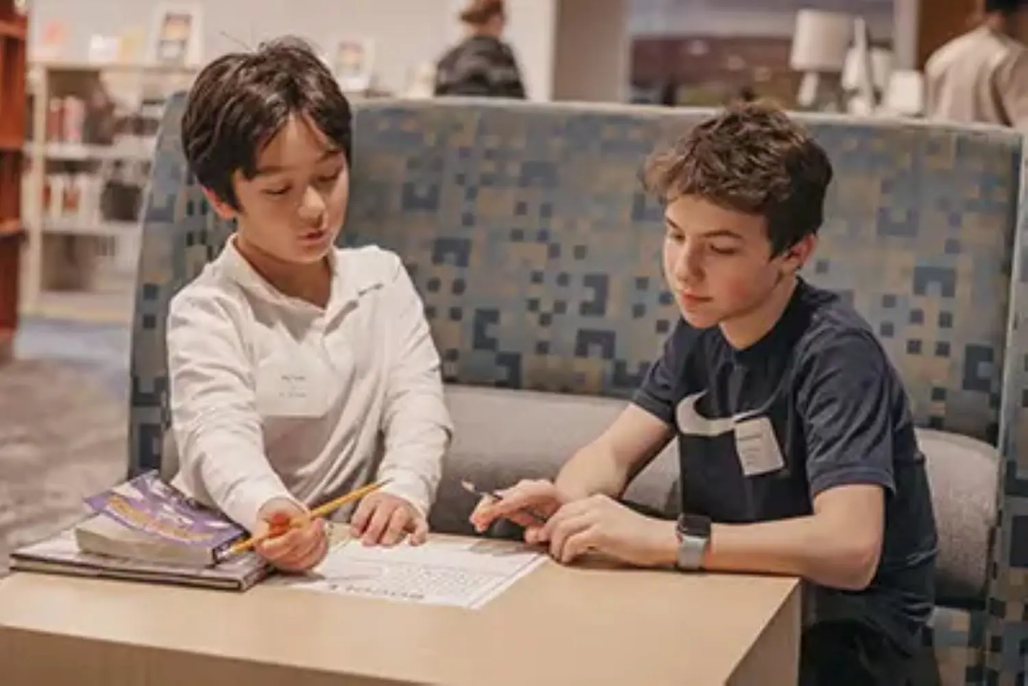 Middle School student working with Lower School student in the Library