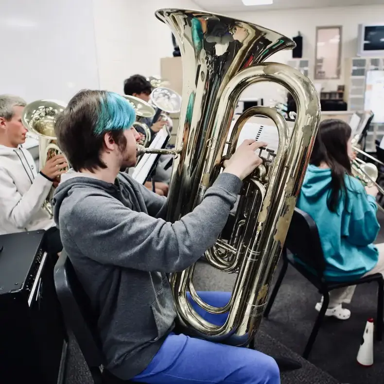 Student playing the tuba in band rehearsal