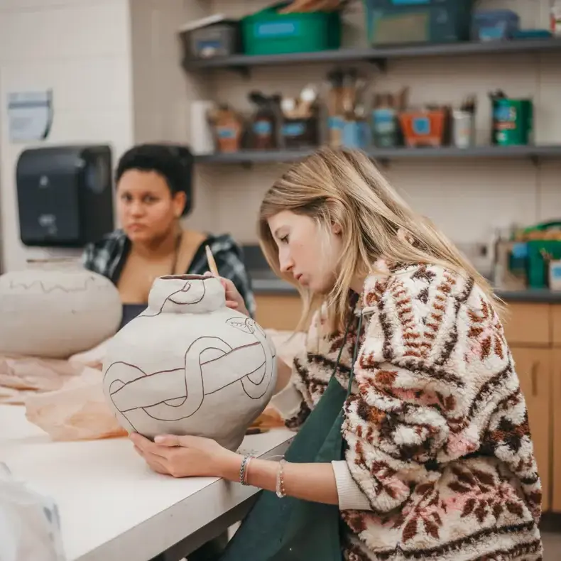 Student sculpting a ceramic art project