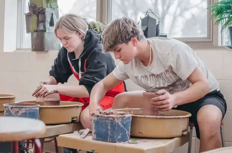 Students engaging in a pottery lesson