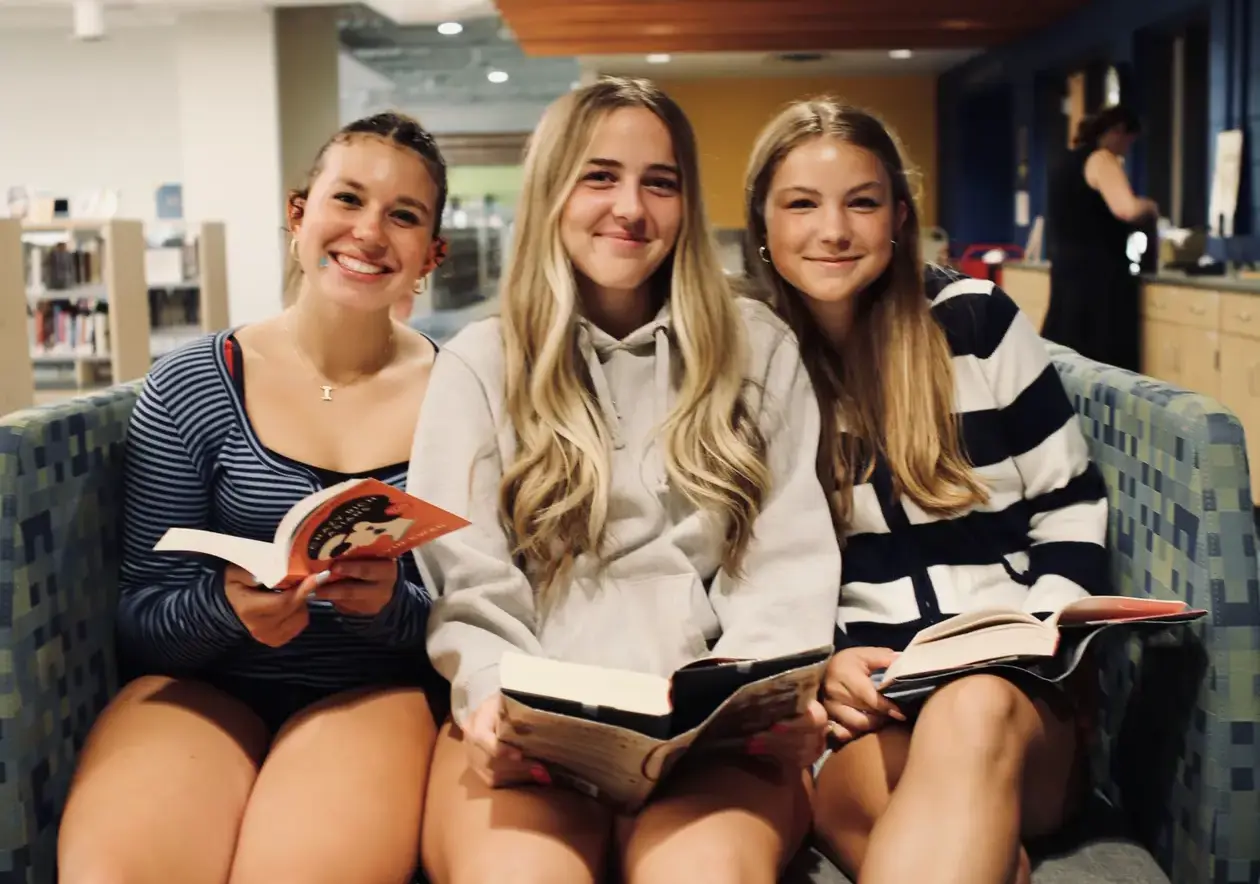 Students sitting together holding books