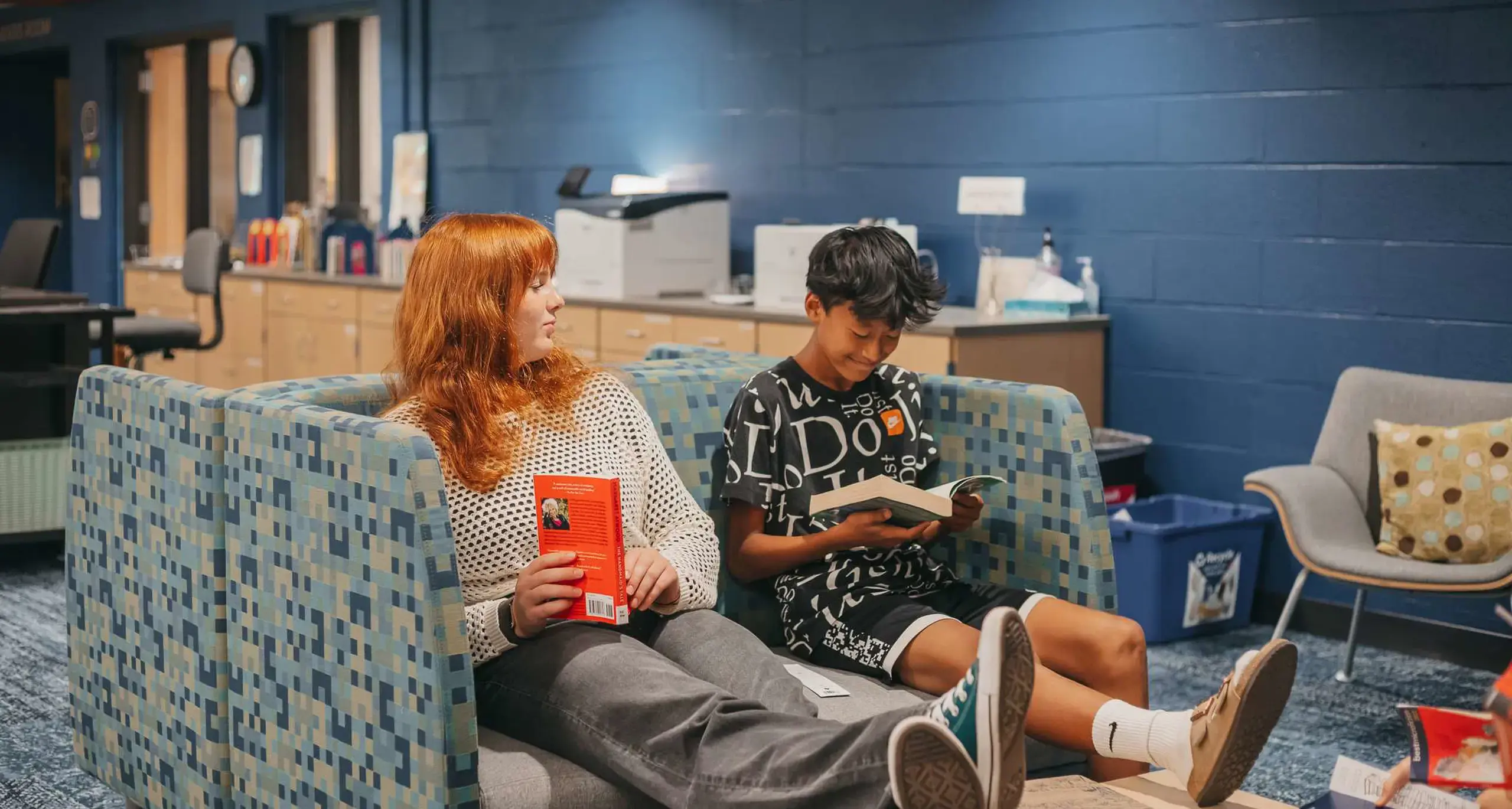 Students reading together in a school library lounge
