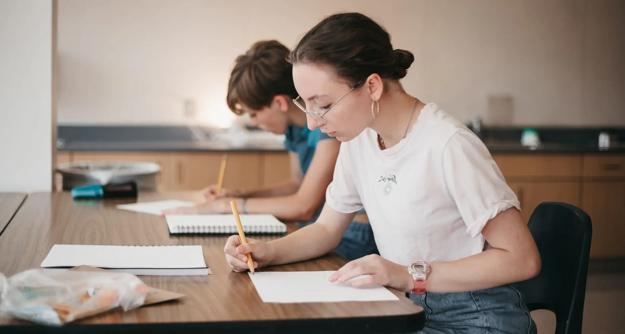 upper school student sitting at a desk writing