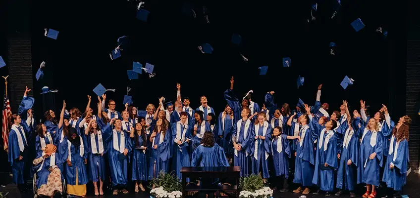 Graduating students throwing their caps in the air
