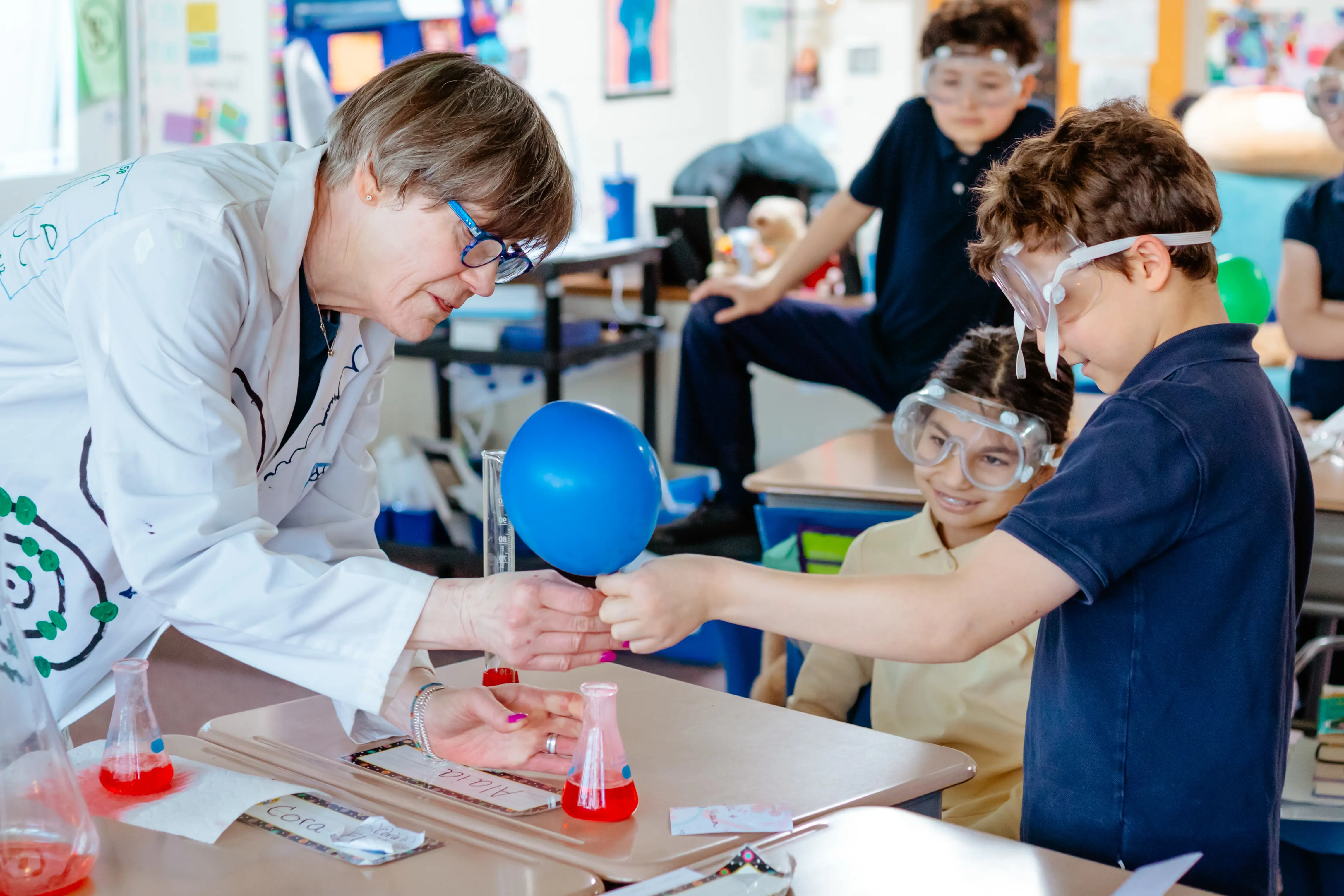 Teacher guiding students through a hands-on science experiment