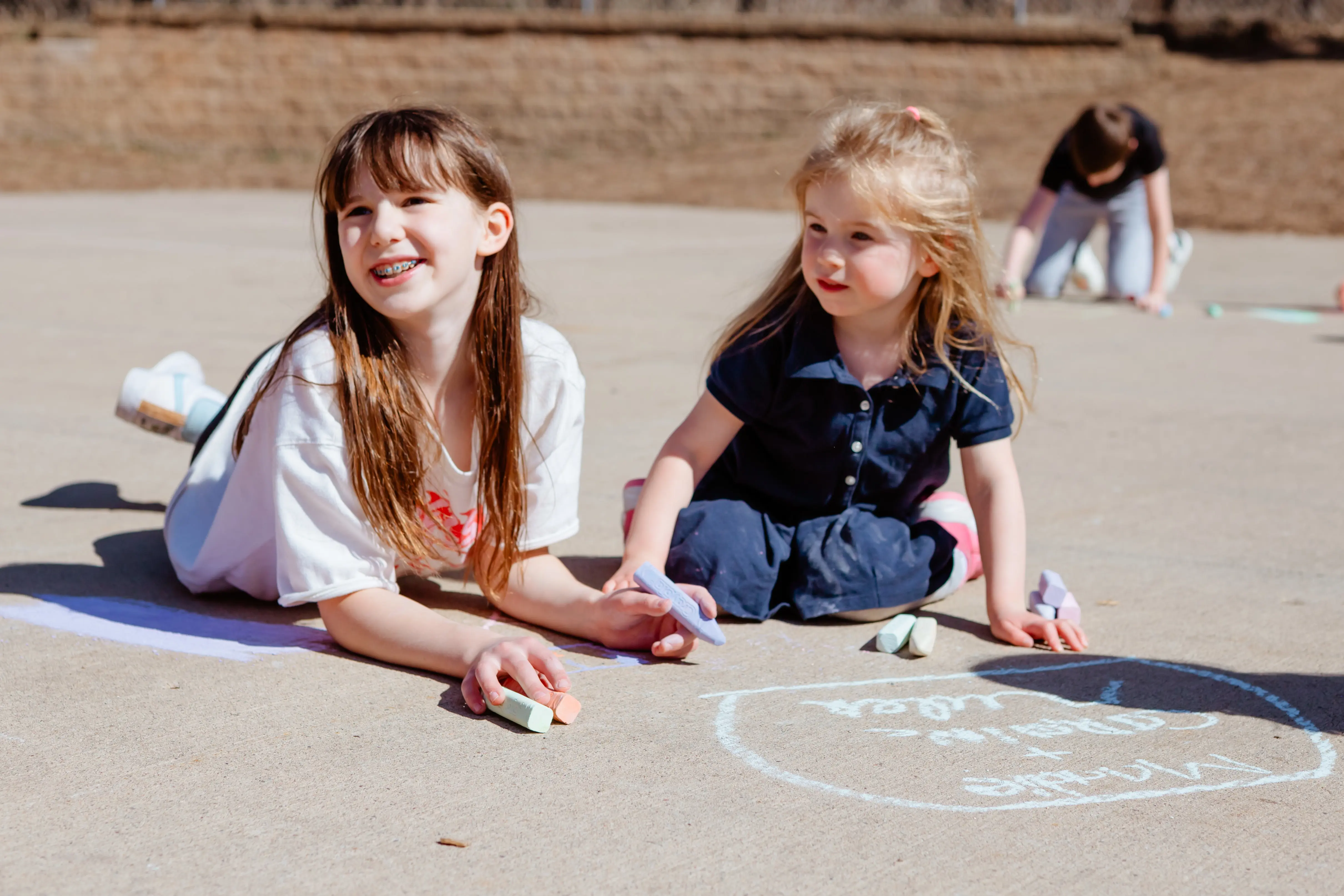 Lower school students drawing with chalk on the floor