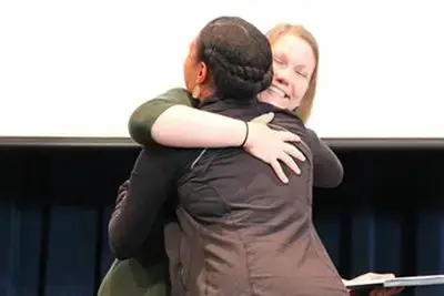 Teacher congratulating student receiving an award.