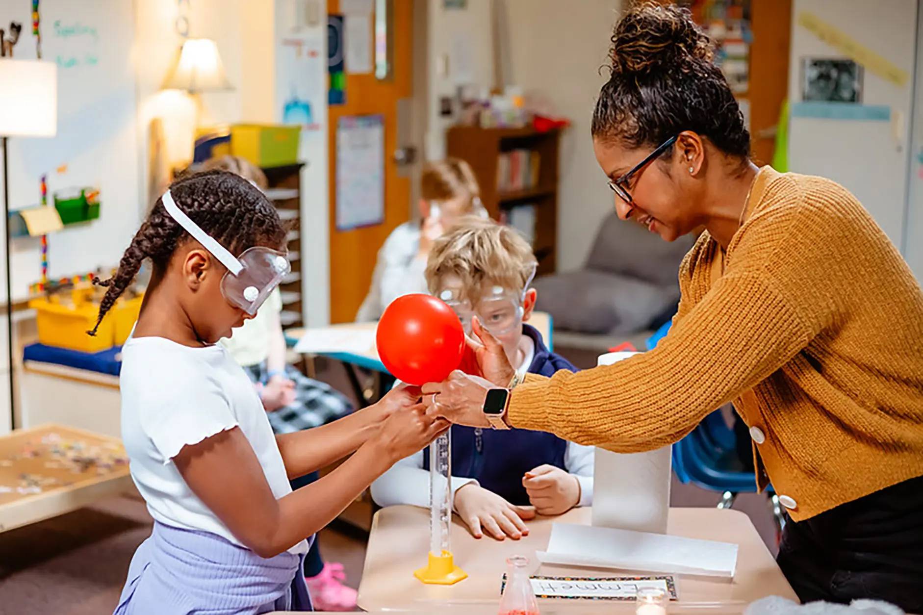 Teacher guiding a student through a hands-on science experiment.