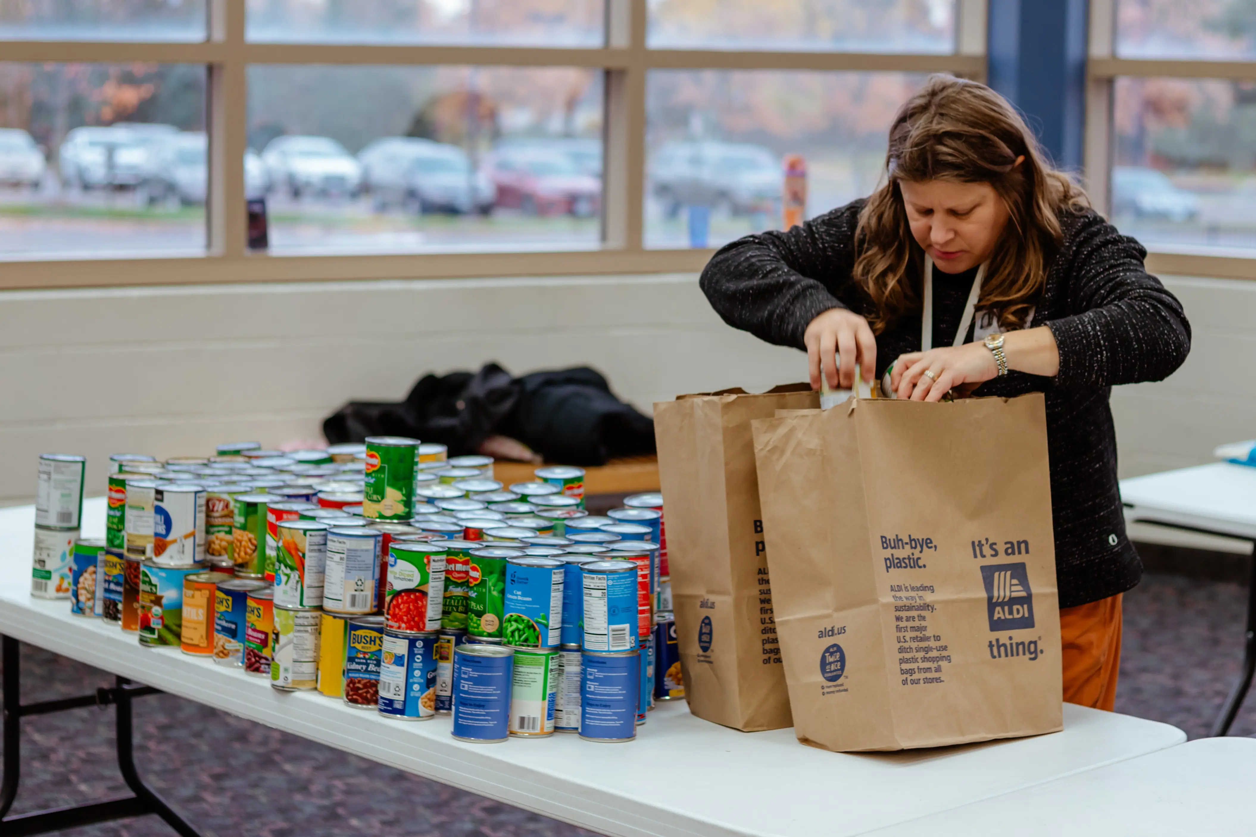 Volunteer organizing food donations for a school food drive.