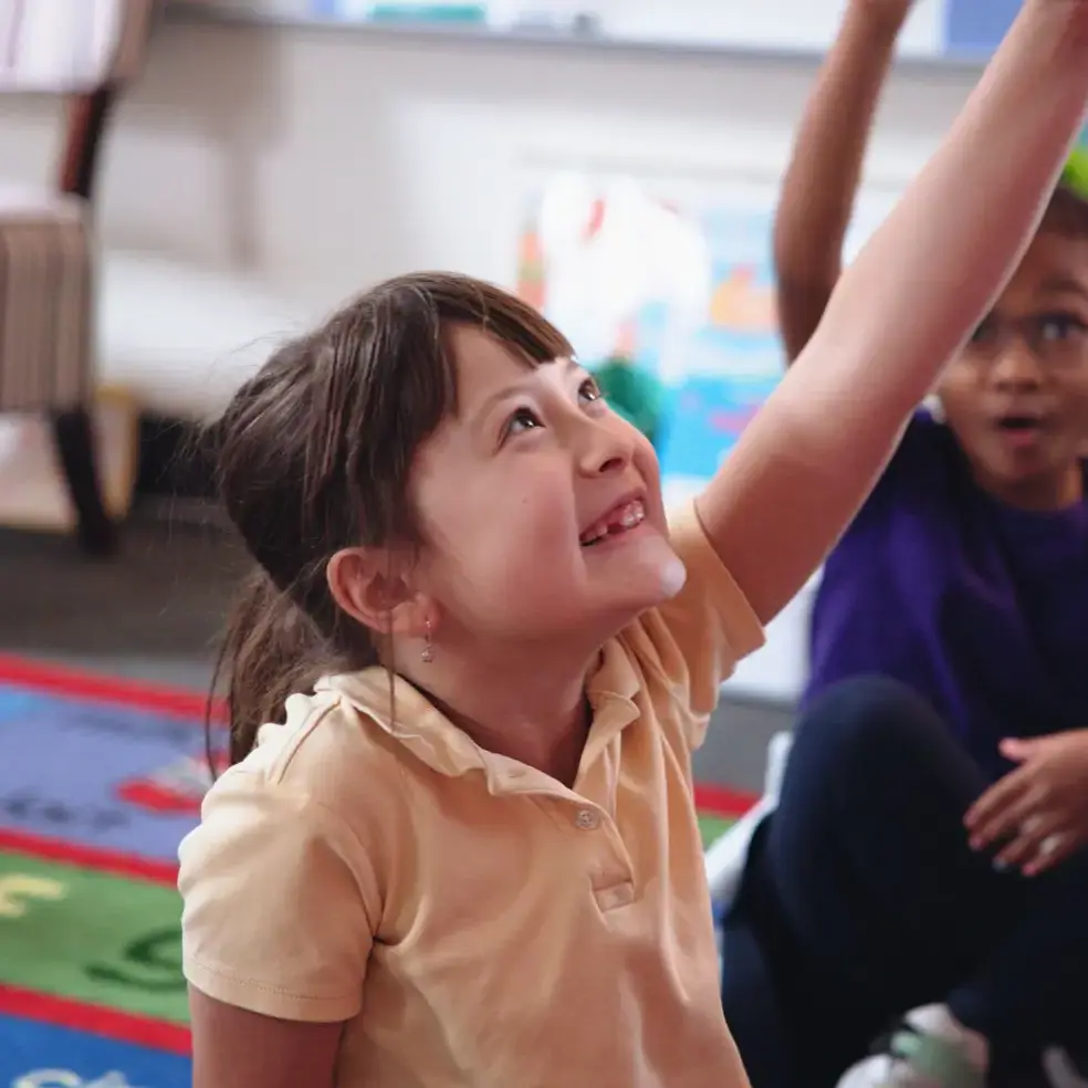 Student raising her hand to answer a question.