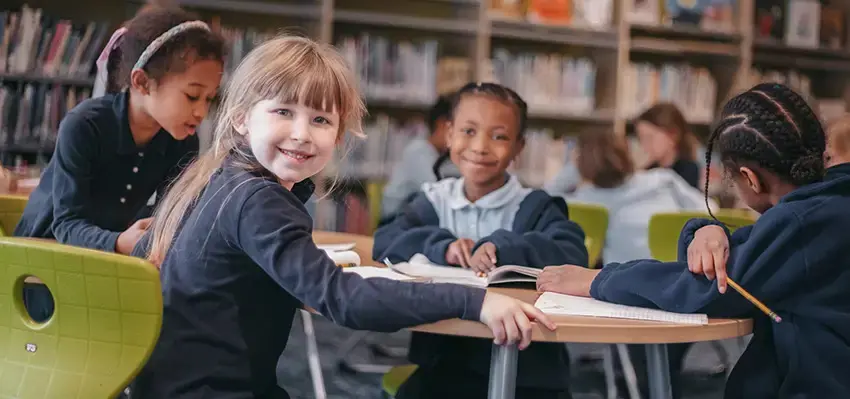 Students sitting at a table smiling