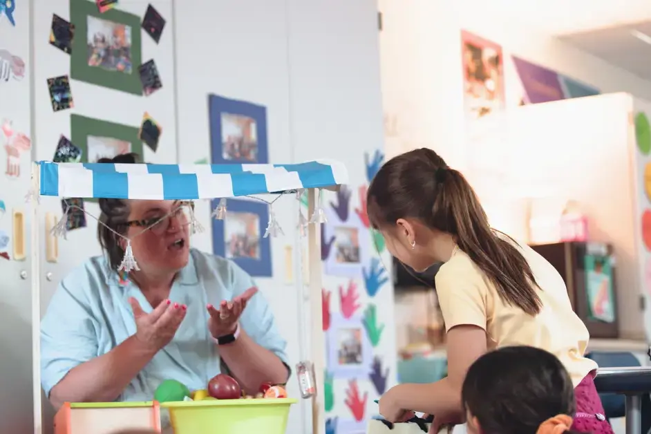 lower school student and teacher role playing a shop scenario