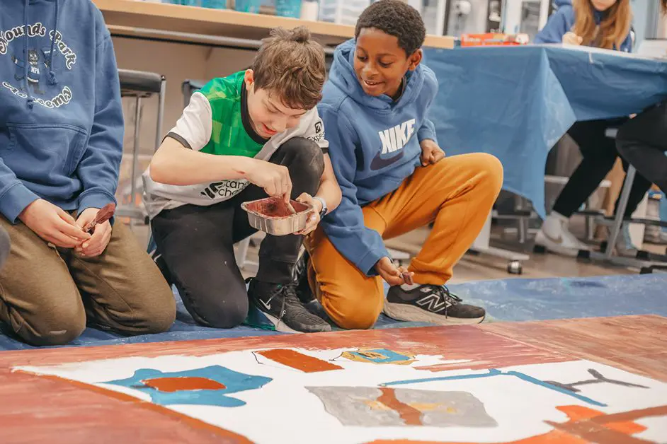 Middle school students painting a collaborative mural.