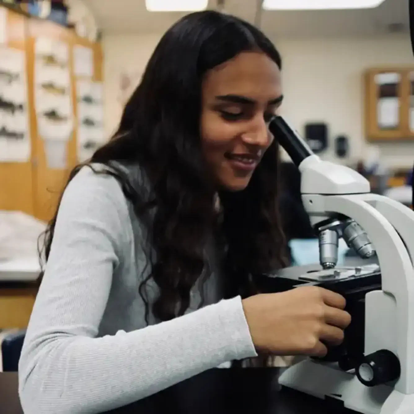 Student looking through a microscope