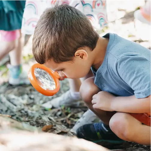 Student looking through a magnifying glass