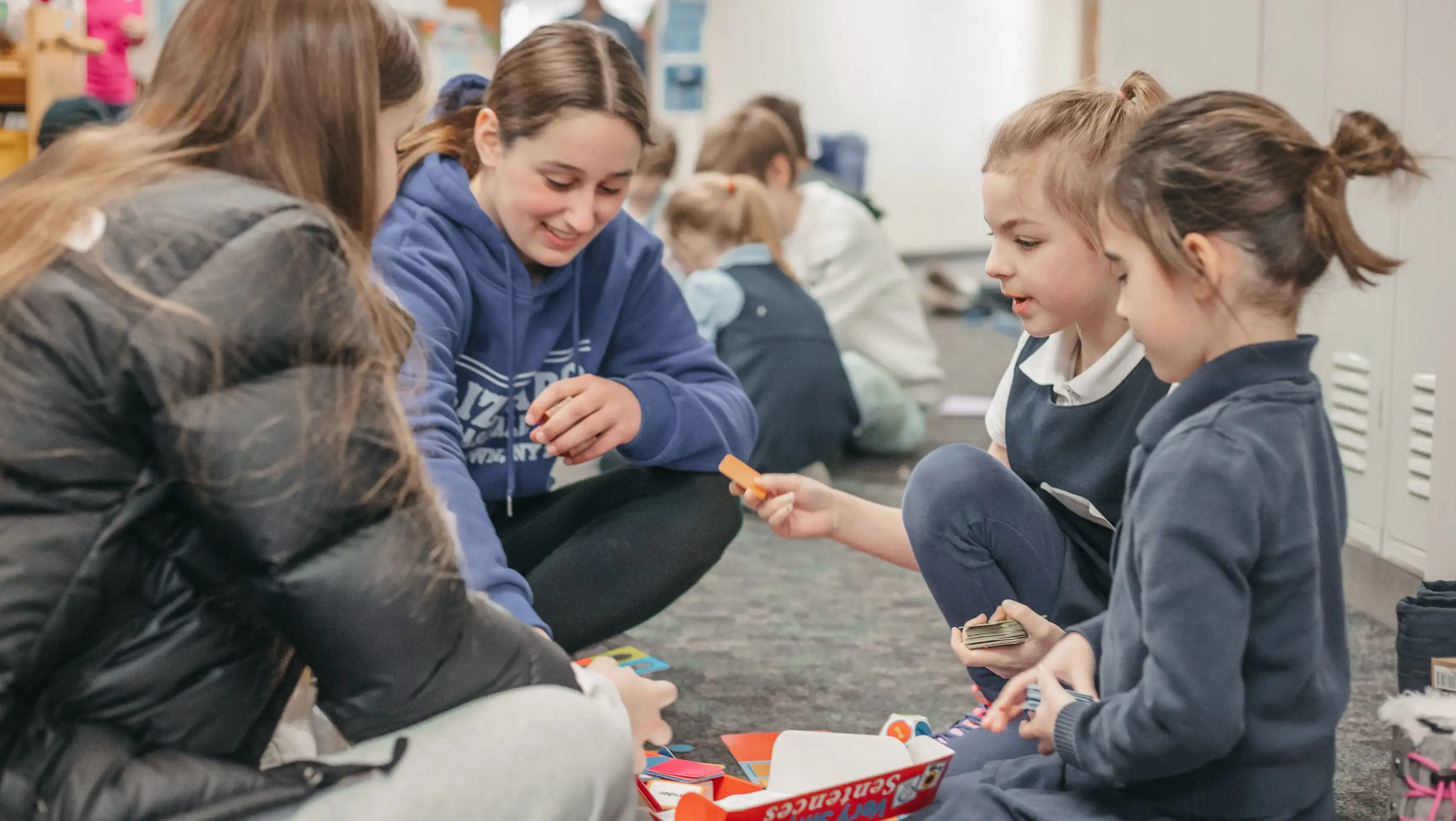 Middle school students engaging in an activity with lower school students